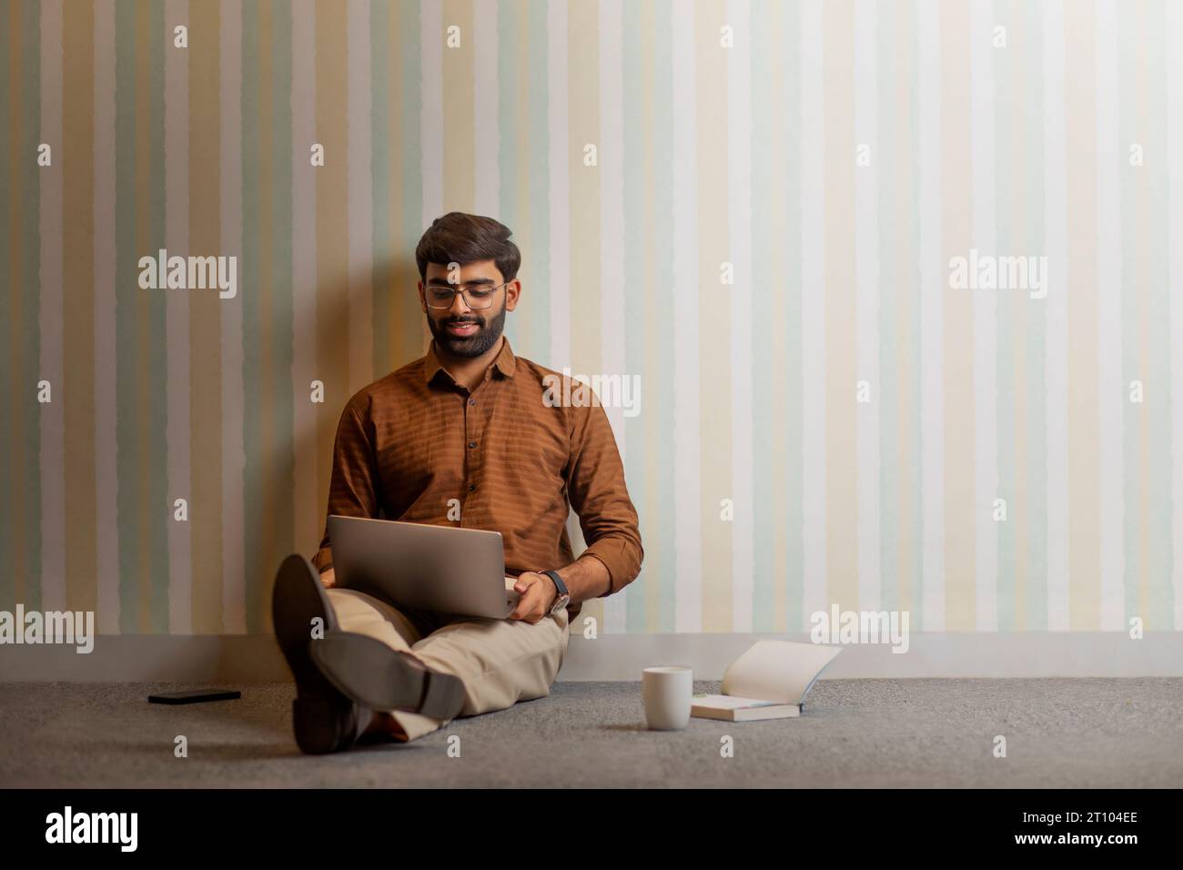Junger Mann, der mit Laptop in seinem Heimbüro arbeitet Stockfoto