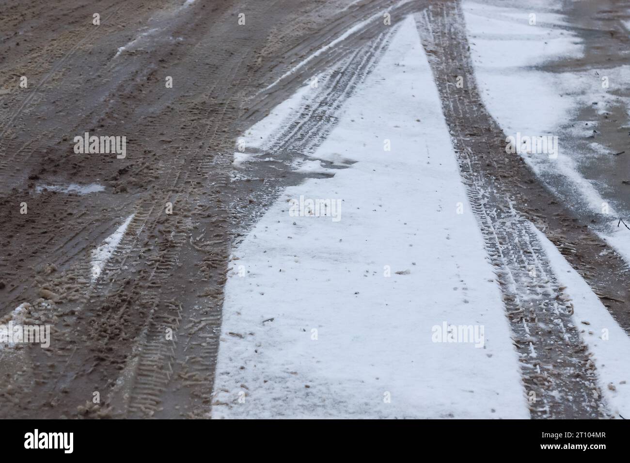 Autospuren auf einer verschneiten Straße. Rutschige Straße, Gefahr, Rutschgefahr. Spuren von Winterreifen. Stockfoto