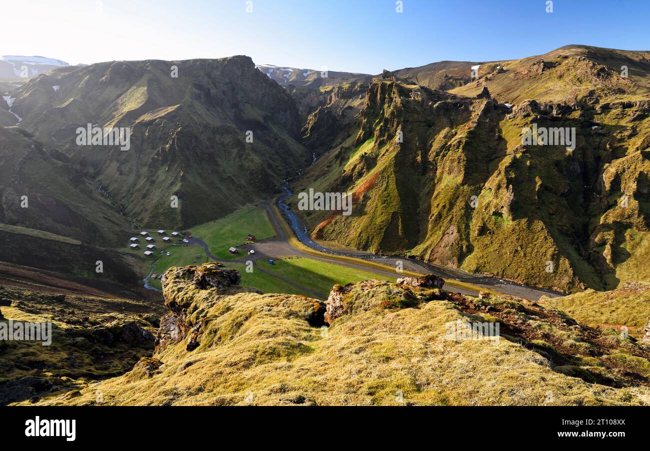 Blick von oben auf den Campingplatz Thakgil bei Sonnenuntergang (Campingplatz Þakgil) in einem wunderschönen Tal, umgeben von Bergen, 20 km von Vík, Island. Stockfoto