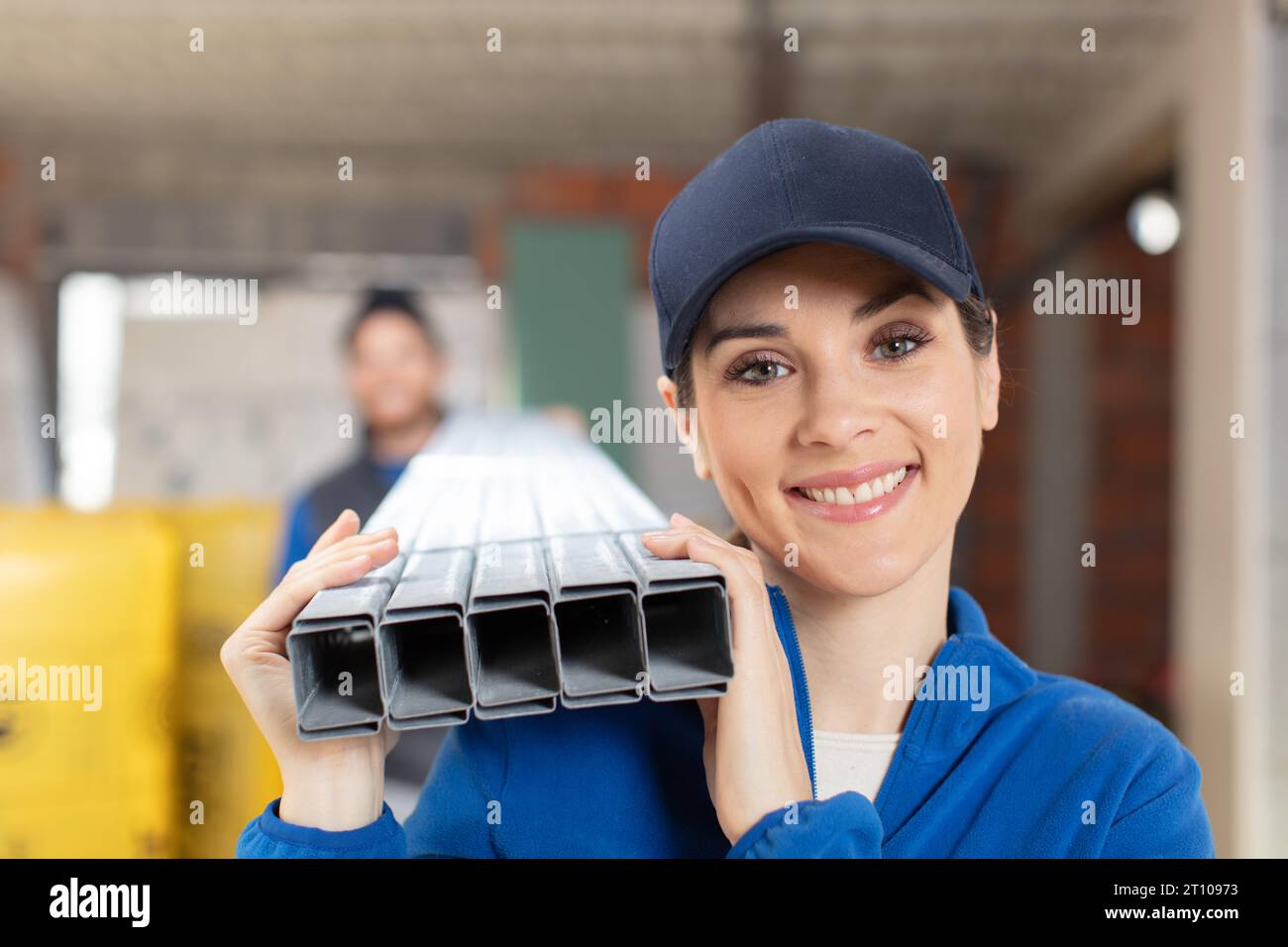 Lächelnde Bauherin liebt Metall mit Kollegen auf den Schultern Stockfoto