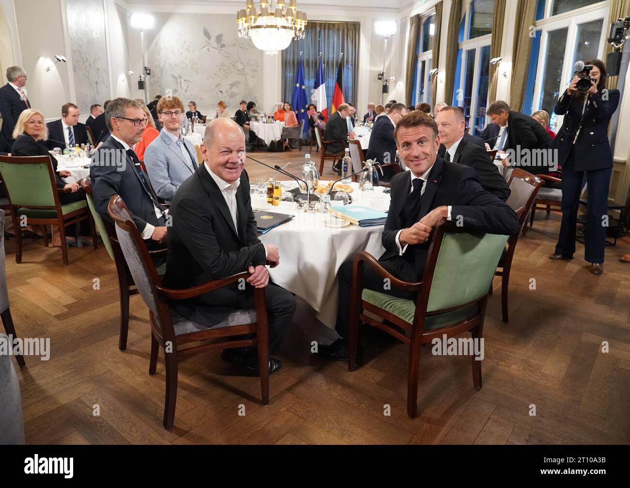 Hamburg, Deutschland. Oktober 2023. Bundeskanzler Olaf Scholz (Front l, SPD) und Emmanuel Macron (Front r), Präsident Frankreichs, sowie die deutschen und französischen Kabinettsmitglieder sitzen im Plenum des Hotels Louis C. Jacob. Das deutsche und das französische Kabinett treffen sich in der Hansestadt zu einem zweitägigen Aufenthalt. Kredit: Marcus Brandt/POOL dpa/dpa/Alamy Live News Stockfoto