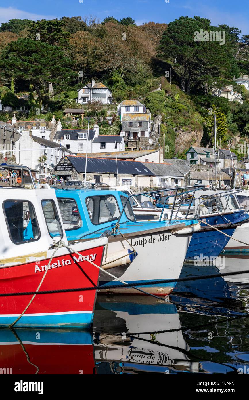 Polperro Inner Harbour, farbenfrohe kleine Fischerboote, die im Hafen dieses kornischen Dorfes, Cornwall, England, Großbritannien, 2023 vor Anker liegen Stockfoto