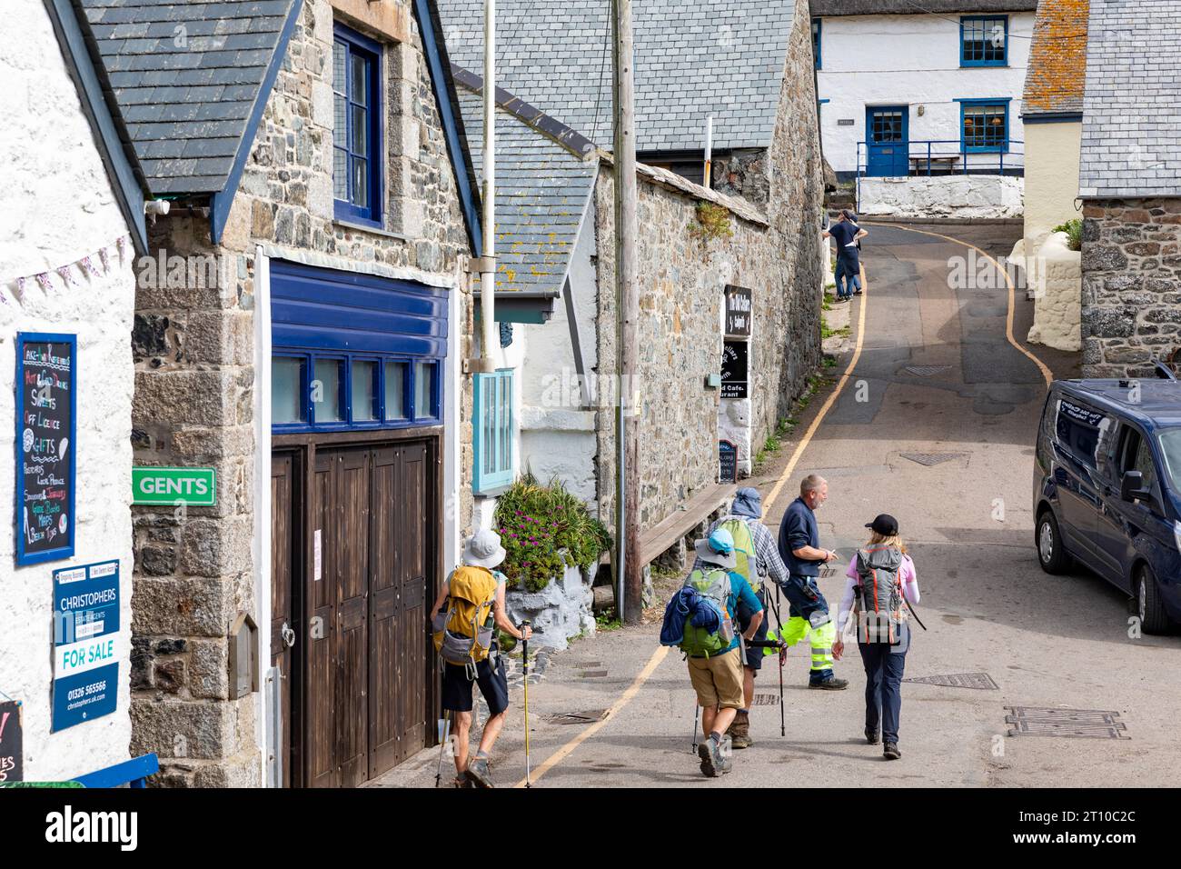 Cadgwith Dorf auf der Lizard Halbinsel in Cornwall, eine Gruppe von männlichen und weiblichen älteren Wanderern, die durch das Dorf laufen, England, UK, 2023 Stockfoto