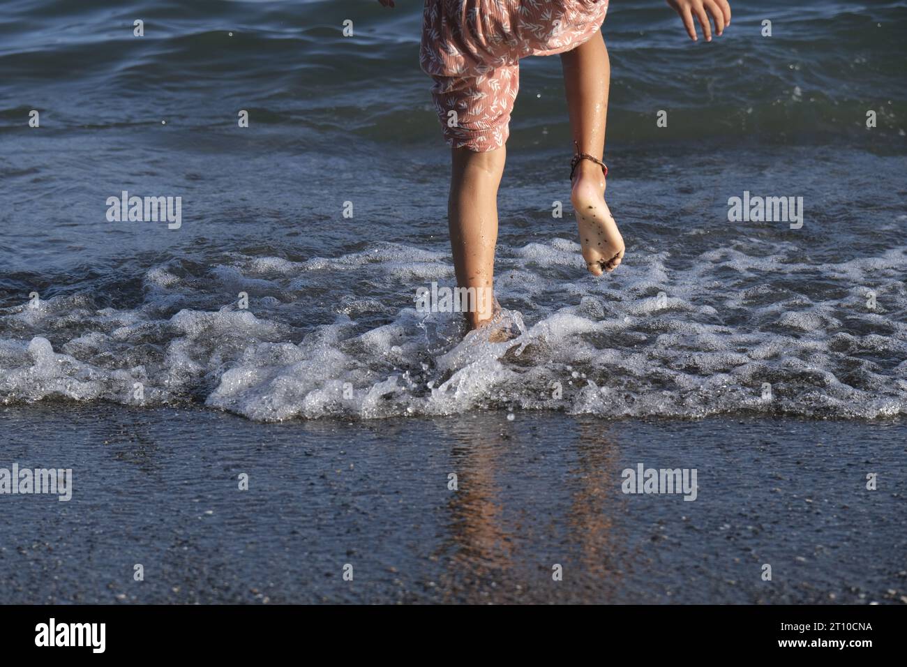 Mädchen springt zufrieden am Ufer und spielt im Herbst Stockfoto