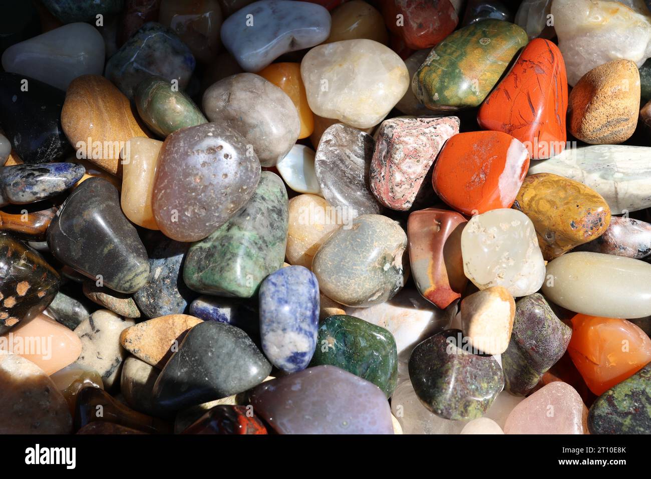 Bunte, glatte Kieselsteine am Strand. Stockfoto