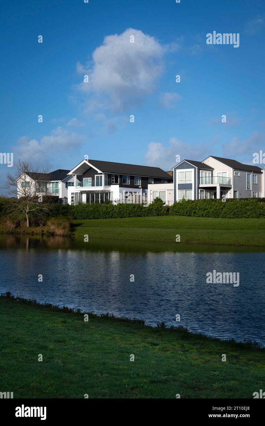 Häuser am See im modernen Vorort Karaka, Auckland, Nordinsel, Neuseeland Stockfoto