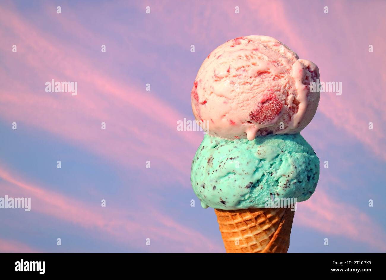 Zwei Kugeln schmelzender Eiskegel auf rosa Abendhimmel Hintergrund Stockfoto