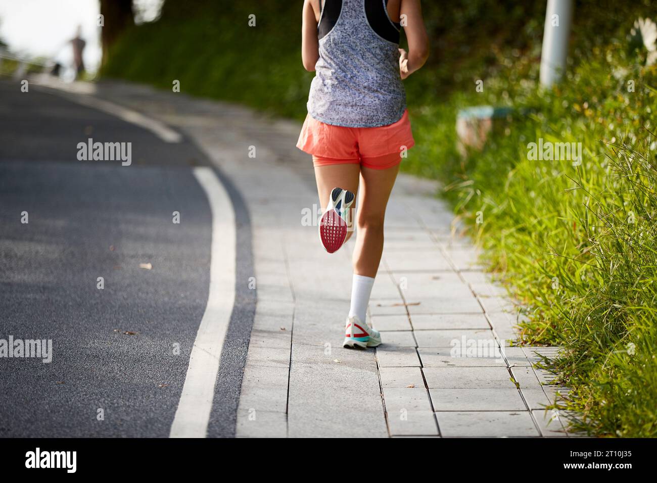 Rückansicht einer jungen asiatischen Joggerin, die im Stadtpark im Freien trainiert Stockfoto