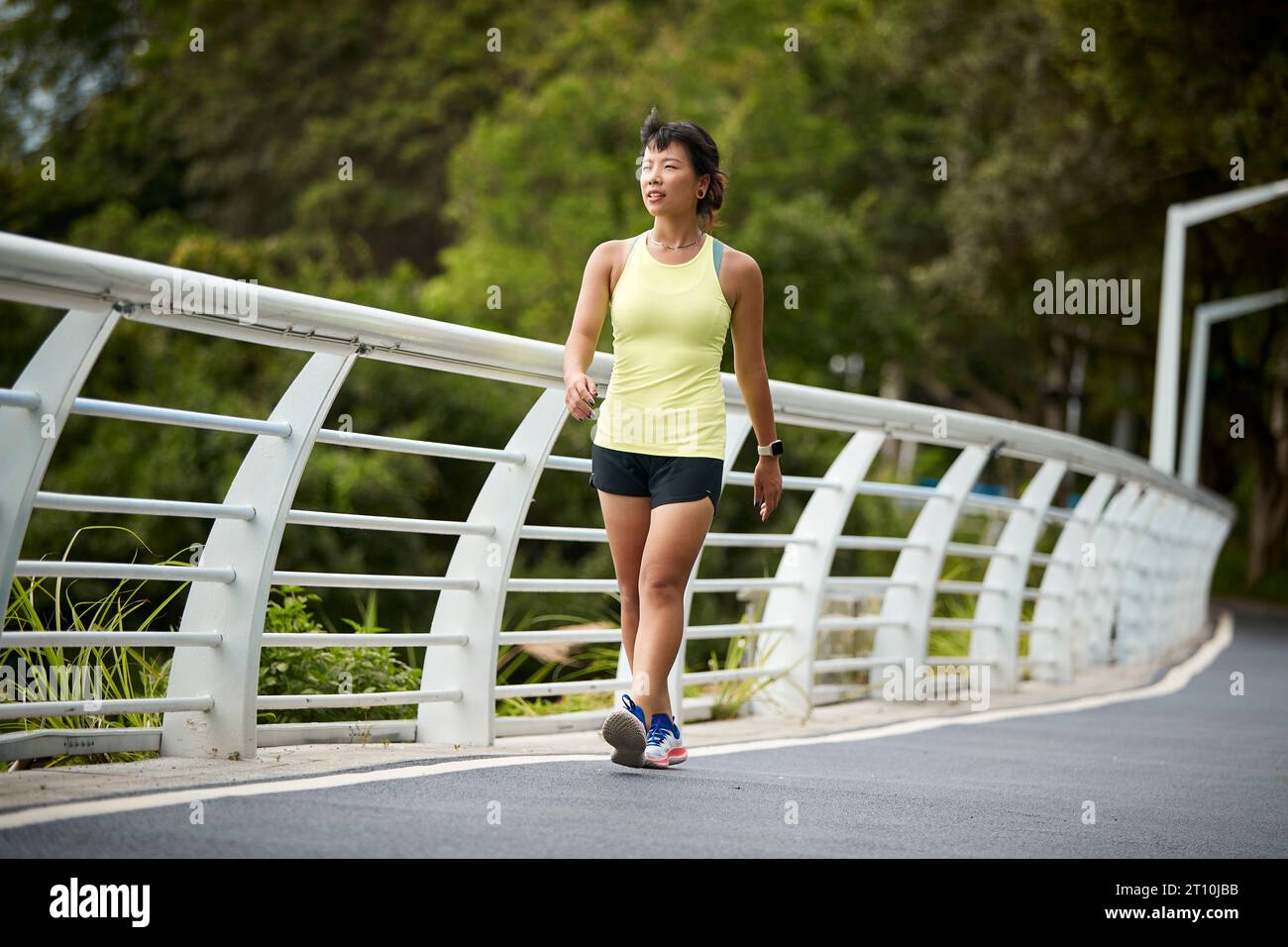 Junge asiatische Frau Joggerin, die sich im Stadtpark erholt Stockfoto