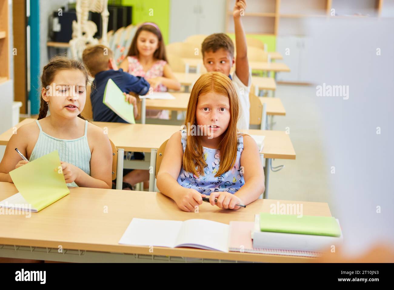 Schüler und Schülerinnen lernen zusammen auf der Bank im Klassenzimmer Stockfoto