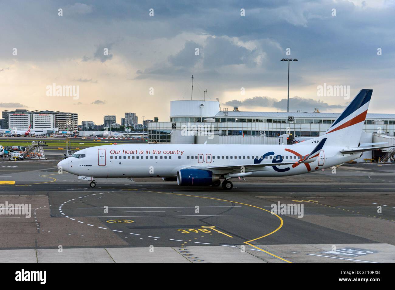 REX Airlines Boeing 737-800 fährt an einem stürmischen Tag auf der Landebahn des Flughafens Sydney, Sydney, New South Wales, Australien Stockfoto