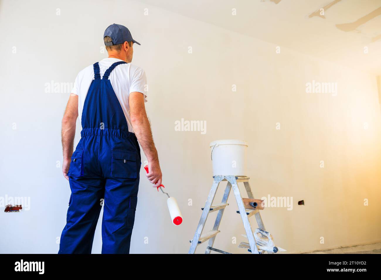 Professioneller Hausmaler macht sich bereit, eine Wand zu malen. Stockfoto