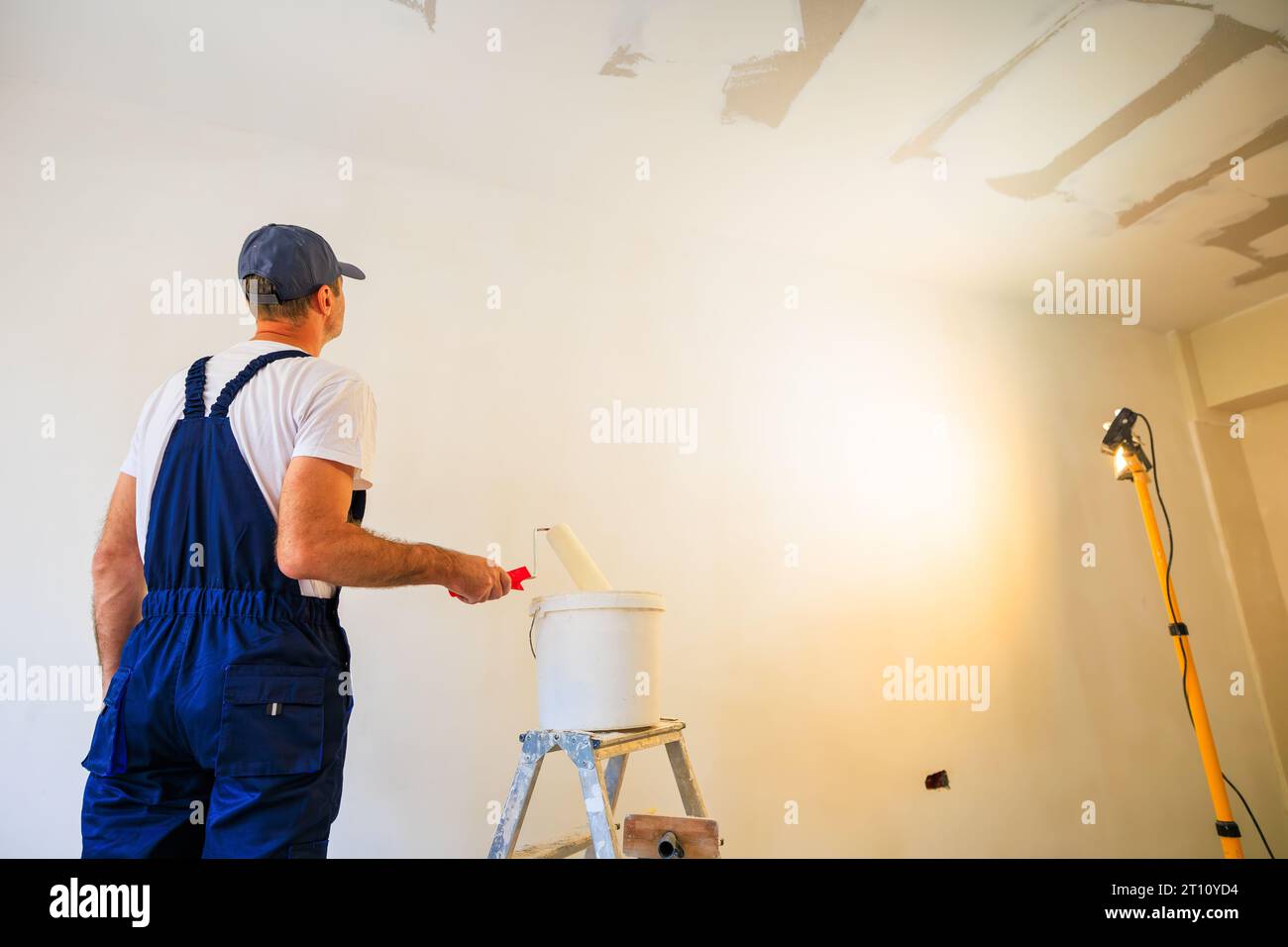 Professioneller Hausmaler macht sich bereit, eine Wand zu malen. Stockfoto
