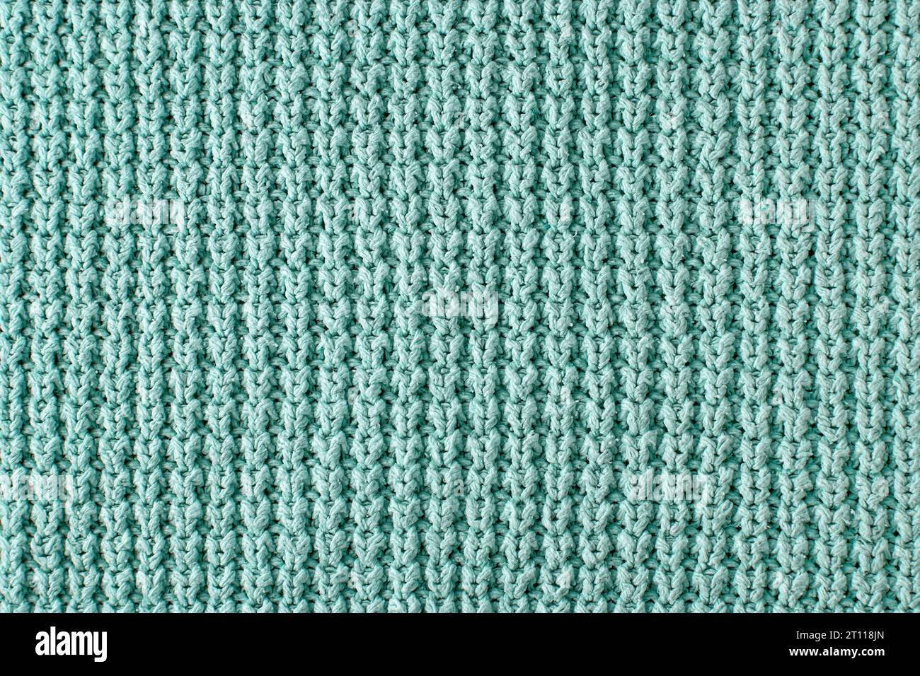 Textur eines groben Strickpullovers in Nahaufnahme. Türkisfarbener gestrickter Hintergrund für Layout-Design Stockfoto