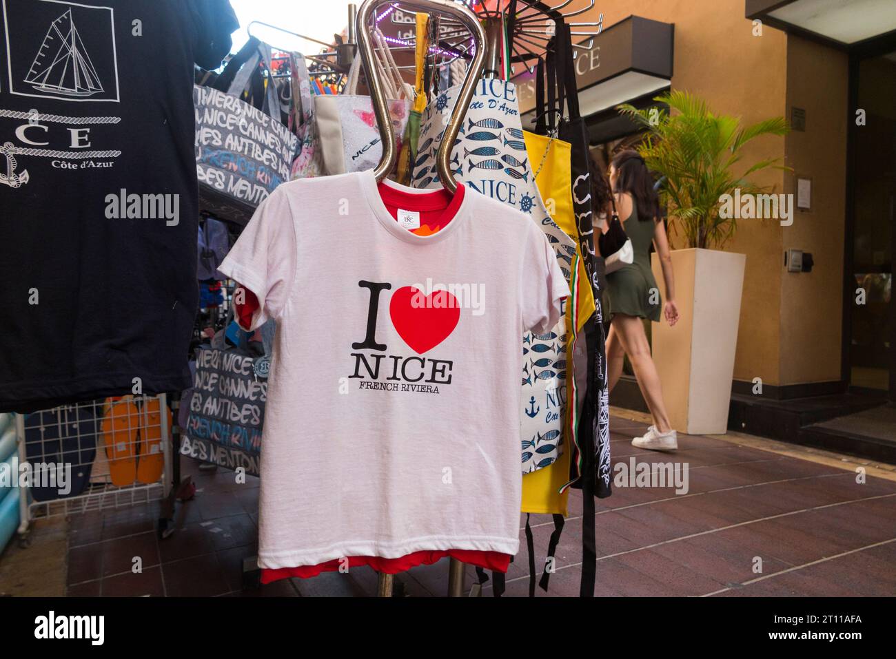 „I Love Nice“ T-Shirt/T-Shirt, das auf dem Gehsteig hängt, mit Herzlogo, zum Verkauf in einem Souvenirladen für Touristen in Nizza, Frankreich. (135) Stockfoto
