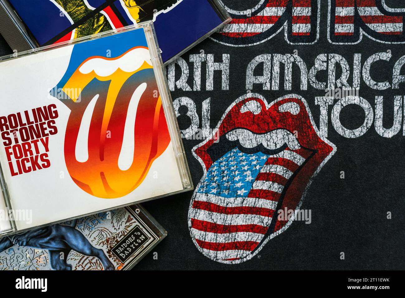 CDs der britischen Rockband The Rolling Stones auf einem T-Shirt mit dem Rolling Stones Logo. Illustrativer Leitartikel Stockfoto