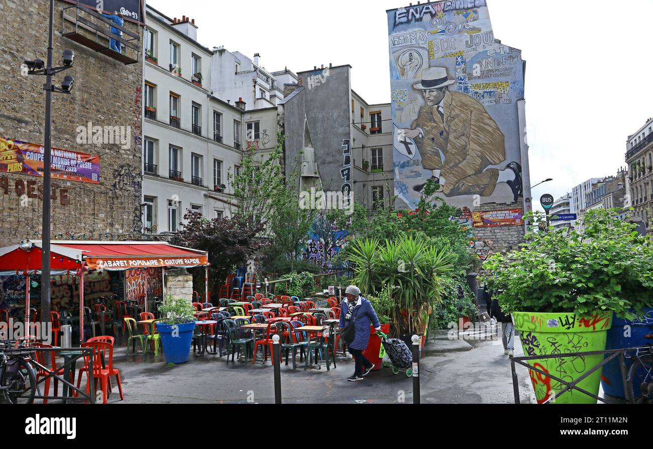 Place Fréhel, Belleville, Paris: Street Art: Kultur die farbenfrohe Mischung aus Plastikstühlen und einem urbanen Garten der Bar Rapide wird von einem riesigen Wandgemälde überschattet Stockfoto
