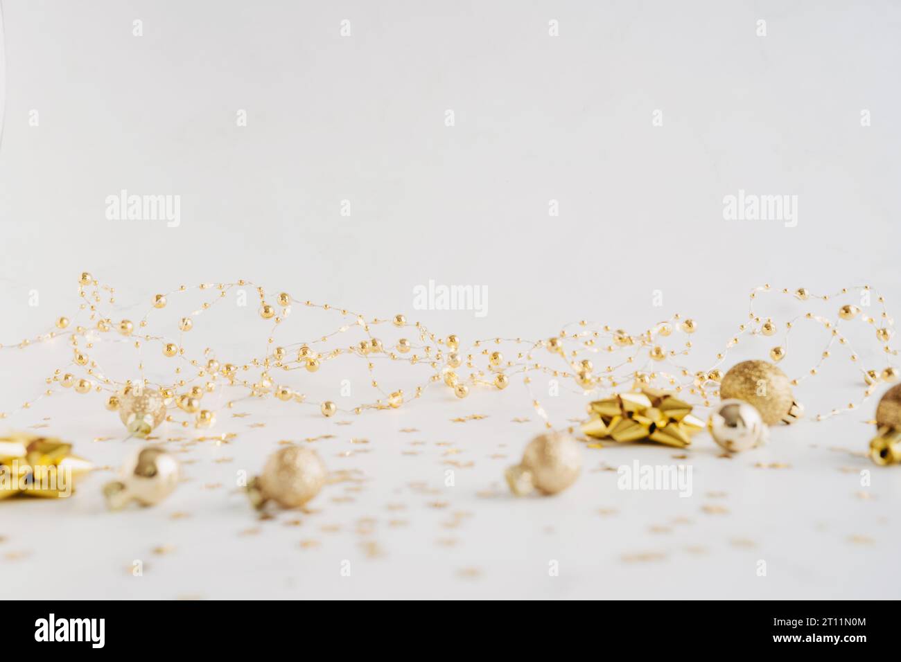 Festlicher Neujahrs- oder Weihnachtshintergrund mit goldener Dekoration und Kopierraum für Text- oder Produktwerbung. Minimales Urlaubskonzept. Vorderansicht. C Stockfoto