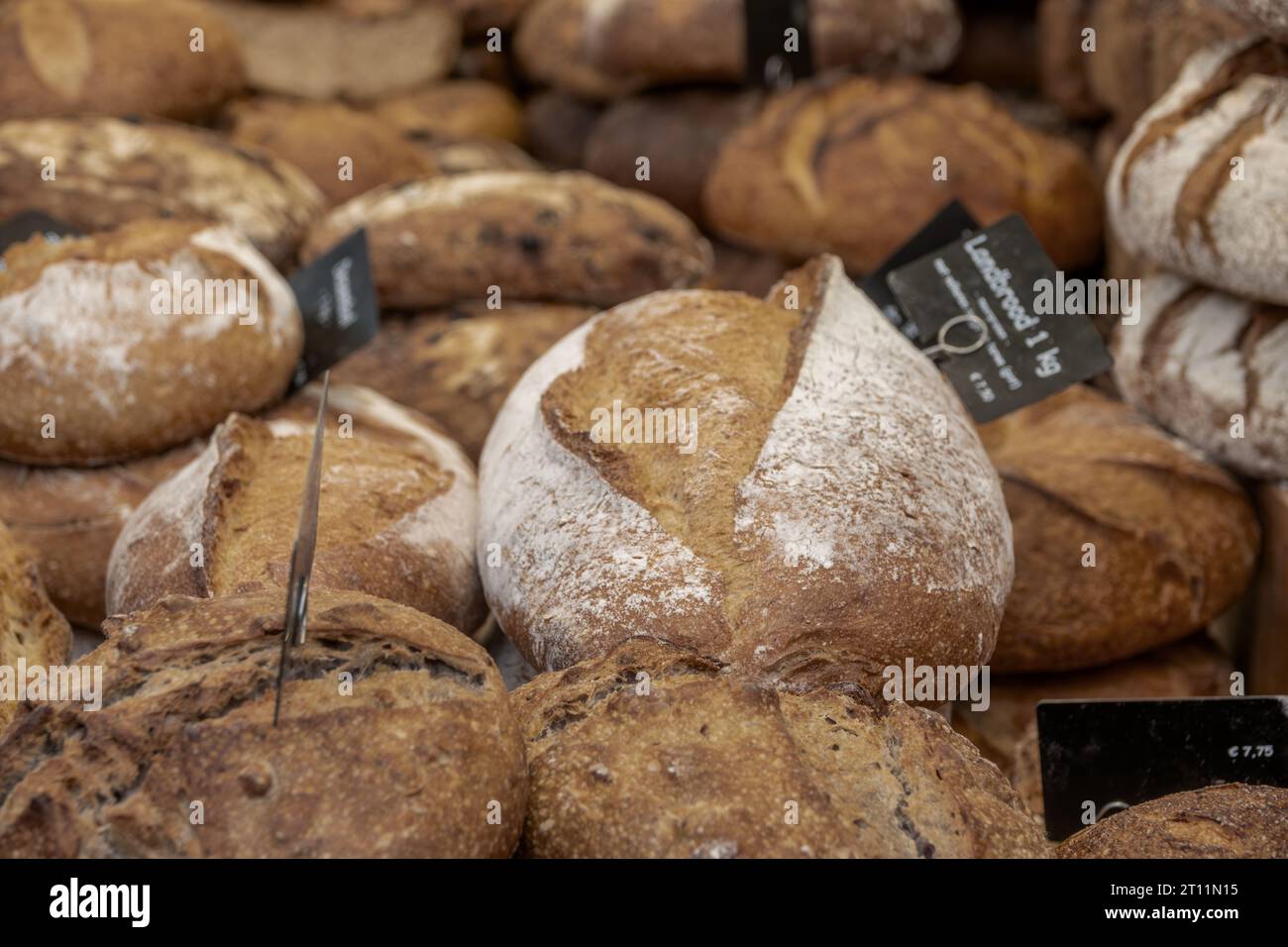 Niederlande. Bauernmarkt in Amsterdam. Viele Laibe frisches Brot aus der Nähe. Auf dem Schild steht "Landbrot" auf Niederländisch Stockfoto