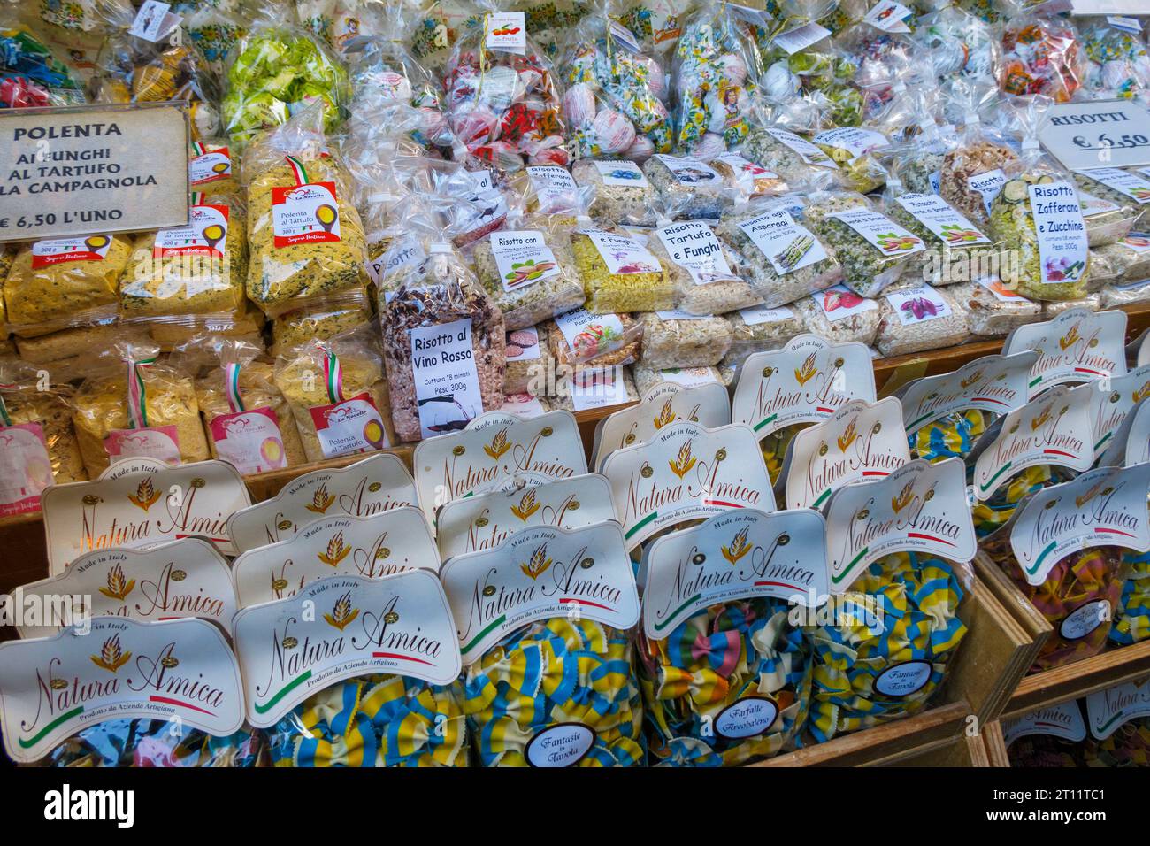 Präsentation verschiedener verpackter italienischer Pasta und Risotto an einem Marktstand, mit verschiedenen Aromen und farbenfrohen Verpackungen Stockfoto