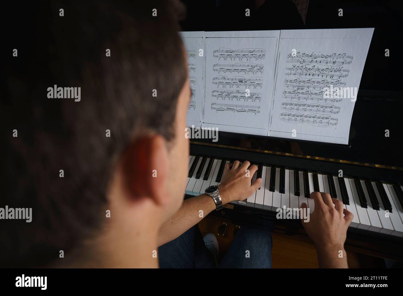 Rückansicht einer Person, die Klavier spielt Stockfoto