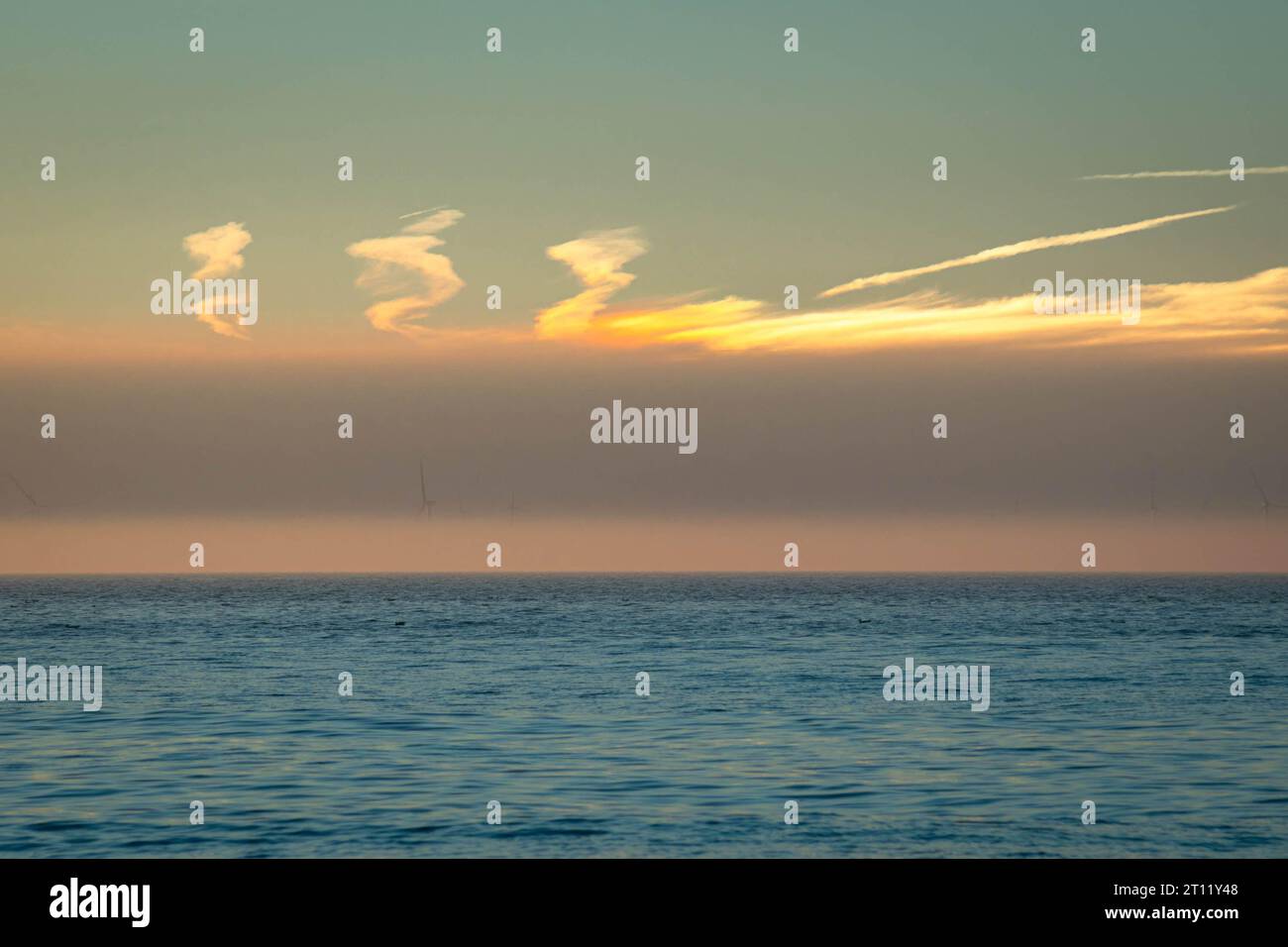 Wolken über der Nordsee bei einem farbenfrohen Sonnenuntergang, bei dem ein sundog oder parhelia in den Wolken sichtbar ist Stockfoto