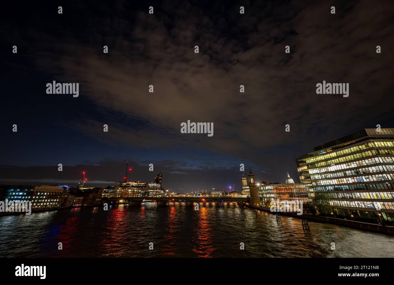 London, Großbritannien: Nachtblick über die Themse von der London Bridge aus in Richtung Blackfriars. Farbige Lichter reflektieren das Wasser. Stockfoto