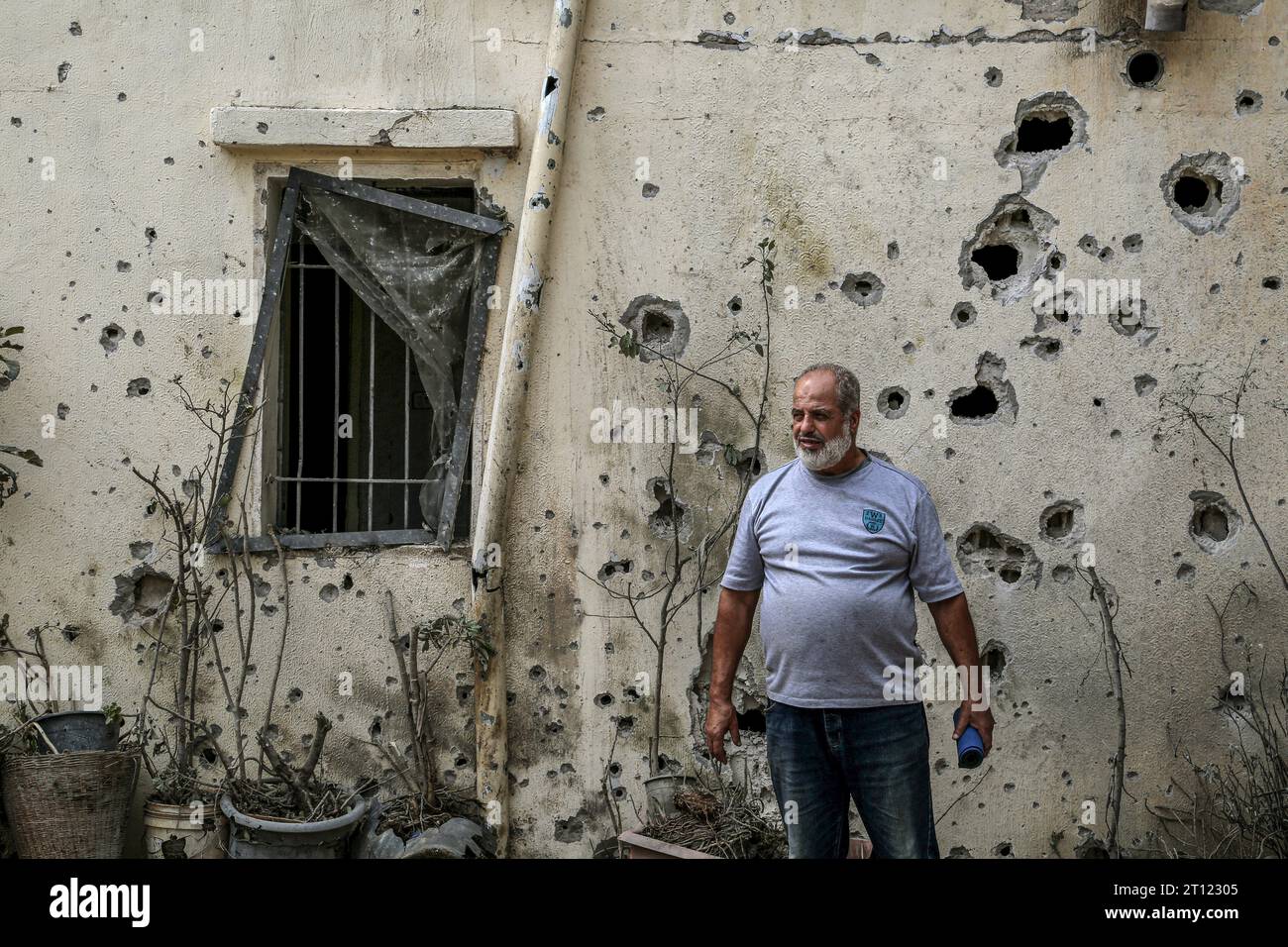 Dhaira, Libanon. Oktober 2023. Abdullah Gharib, Bürgermeister des südlibanesischen Grenzdorfes zu Israel Dhaira, steht vor der durch israelische Bombardierungen verursachten Muschelwand seines Hauses. Zwei palästinensische Militante wurden getötet, als sie einen israelischen Posten angriffen, und Israel reagierte mit einem Schlag auf das Dorf und tötete drei pro-iranische Hisbollah-Kämpfer. Marwan Naamani/dpa/Alamy Live News Stockfoto