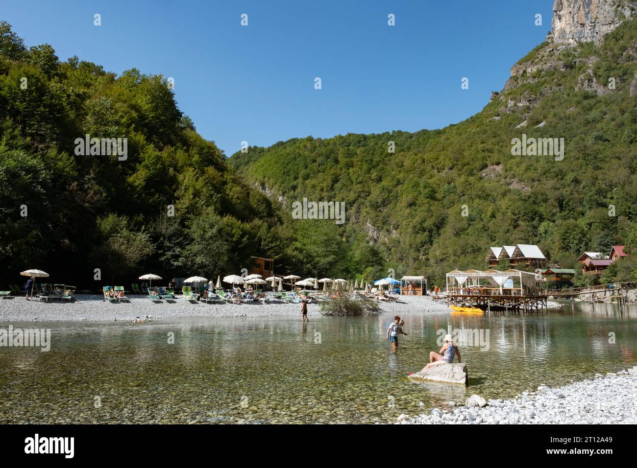 Besucher genießen das warme, ruhige kristallklare Wasser im River Shala Resort in der Nähe des Komani-Sees in Albanien Stockfoto