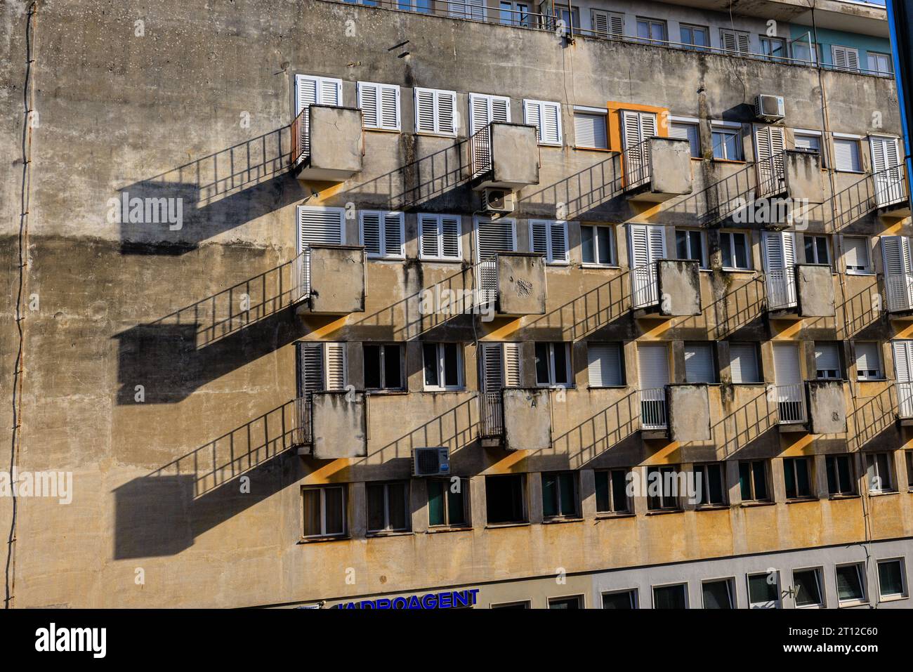 Am späten Nachmittag erzeugt Sonnenlicht geometrische Muster auf Balkonen und Geländern des Gebäudes aus der sozialistischen Ära in Zadar kroatien Stockfoto