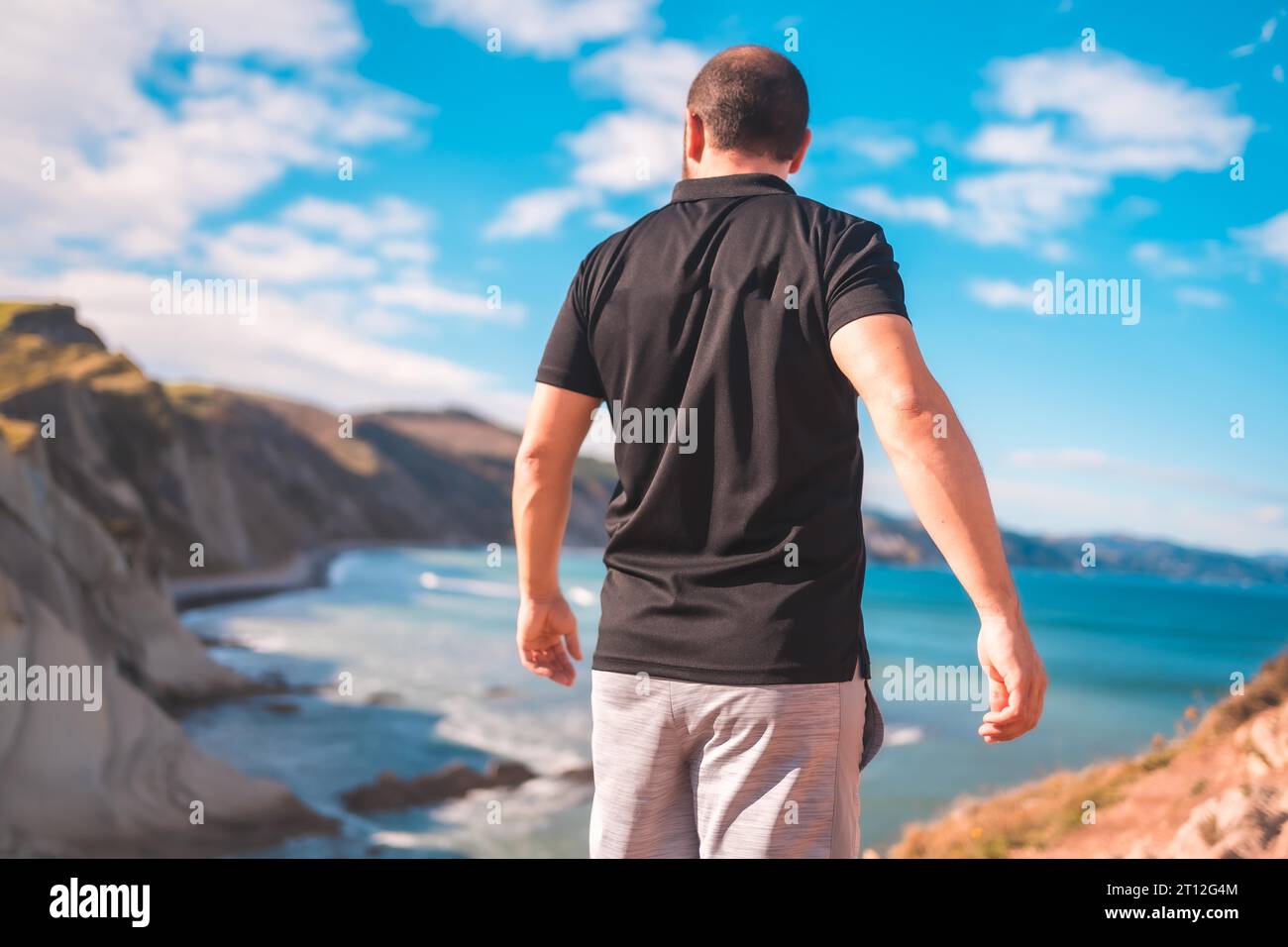 Ein junger Mann genießt einen Sommernachmittag an der Küste des baskenlandes, zumaia. Gipuzkoa Stockfoto