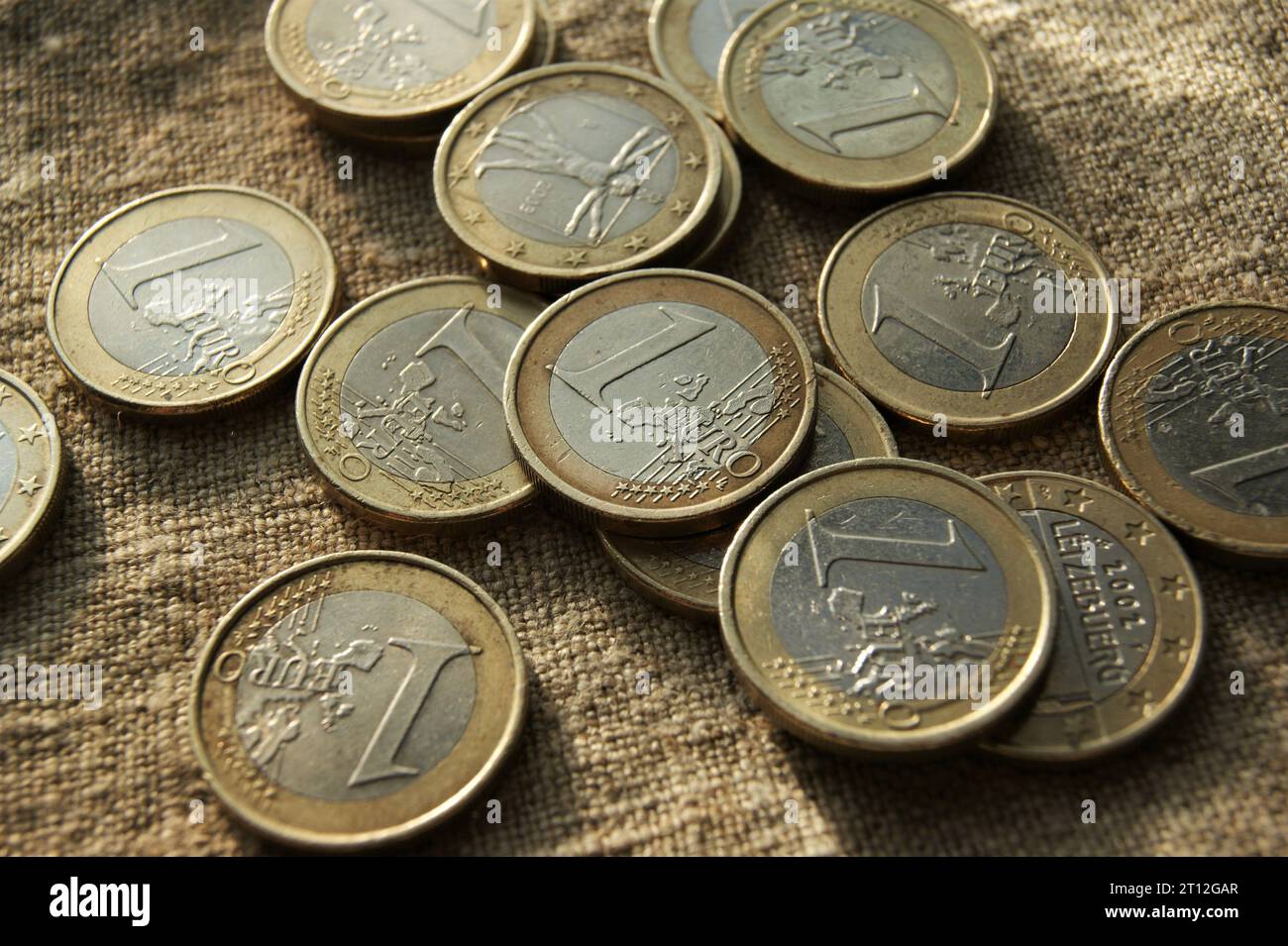 Europäisches Geld. Ich habe 1 Euro-Münzen auf Leinengewebe gegossen. Stockfoto