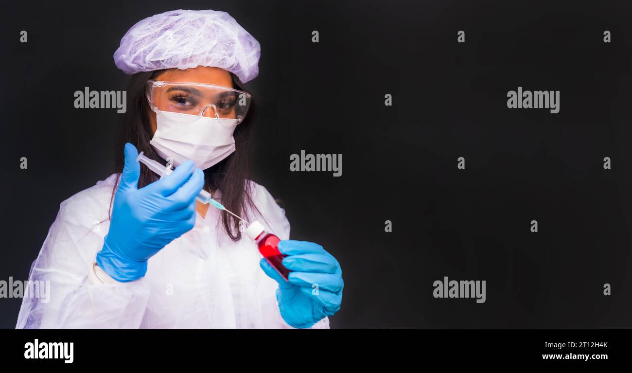 Afroamerikanische Ärztin, die den Coronavirus-Impfstoff mit Kopier- und Pastenraum vorbereitet, immunisiert die Bevölkerung, schwarzer Hintergrund, Antikörper Stockfoto