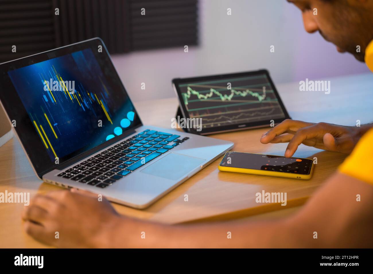 Händler, der Computer und elektronische Geräte verwendet, um von zu Hause aus fernzuarbeiten Stockfoto