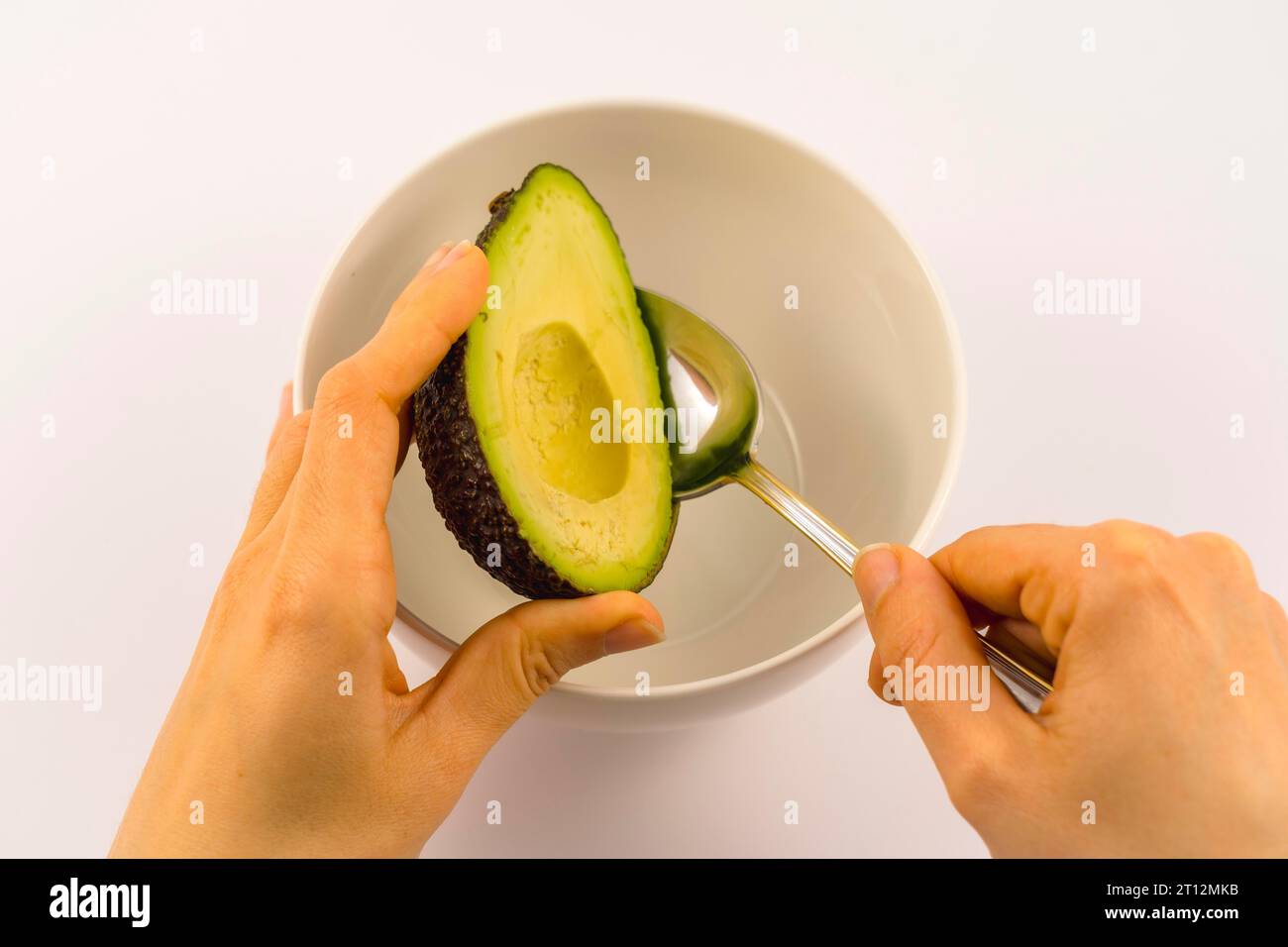 Wir beginnen damit, die Avocado zu leeren. Rezept zur Zubereitung einer Guacamole Stockfoto