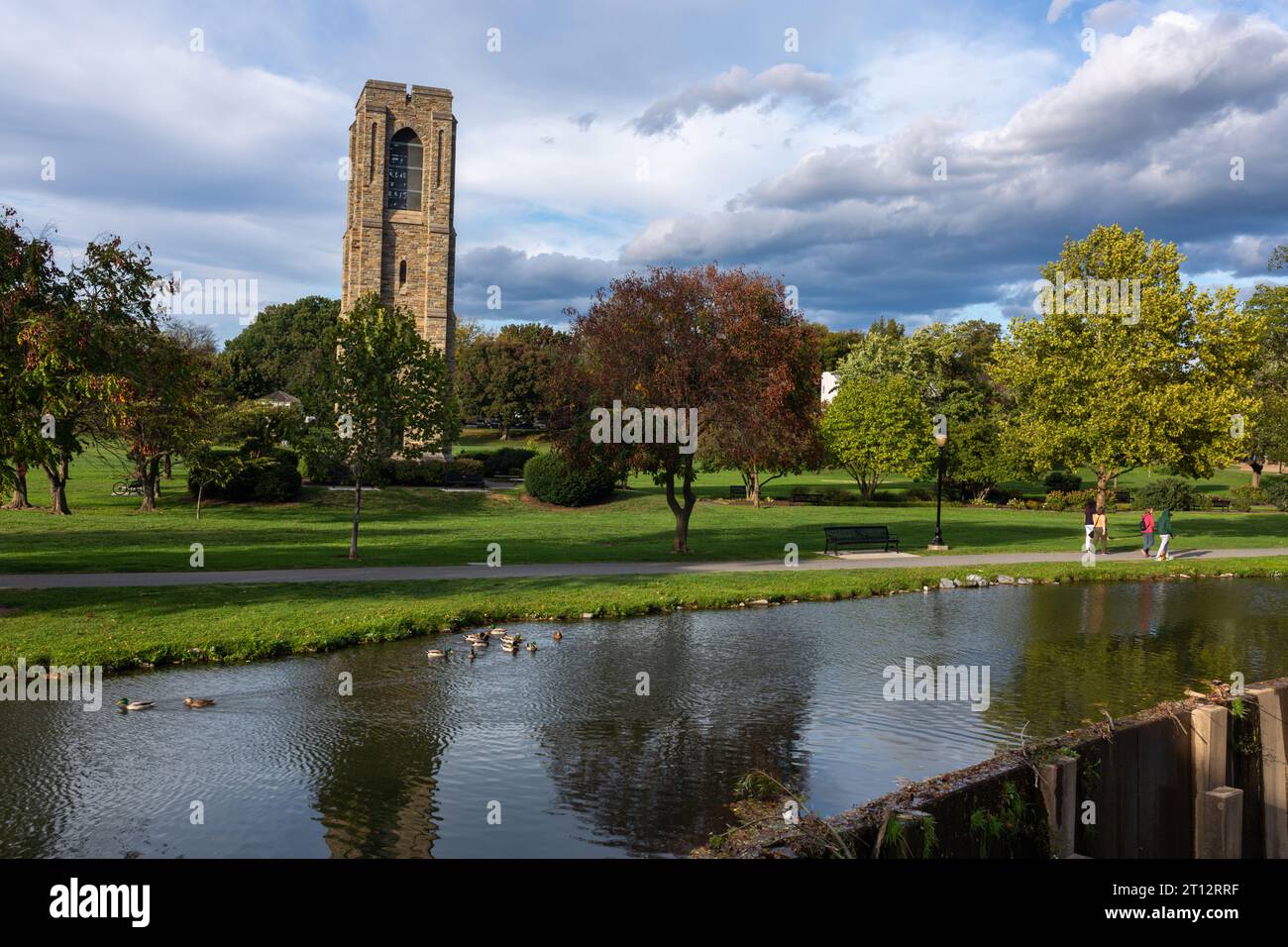 Die ruhige Szene in Frederick, MD: Der Carroll Creek Damm, der berühmte Carillon Tower und eine riesige grüne Rasenfläche bieten einen ruhigen, urbanen Rückzugsort im Baker Park. Stockfoto