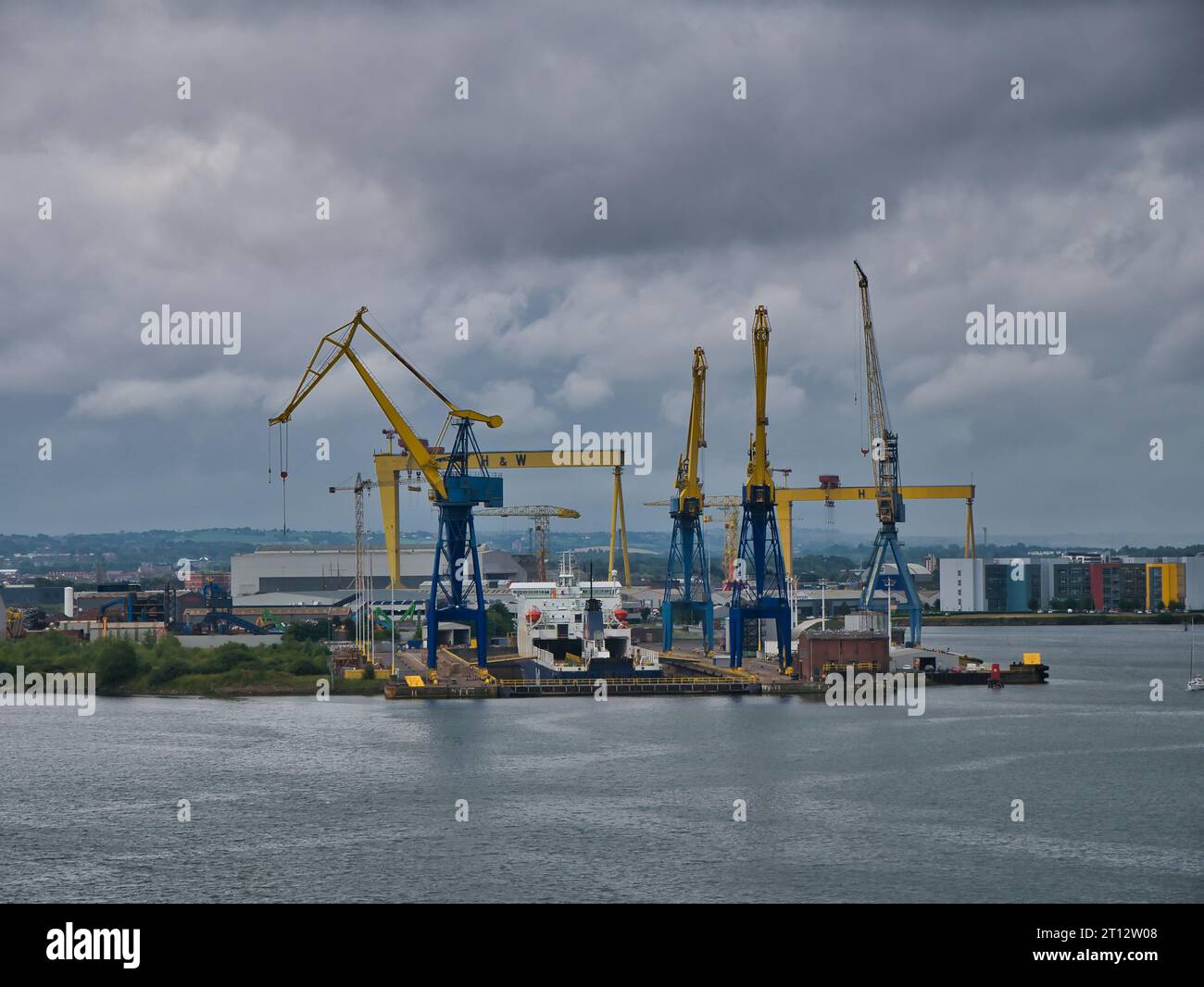 Kräne umgeben ein Schiff im Trockendock im Hafen von Belfast in Nordirland, Großbritannien. Die Samson- und Goliath-Krane der Harland and Wolff Werft App Stockfoto