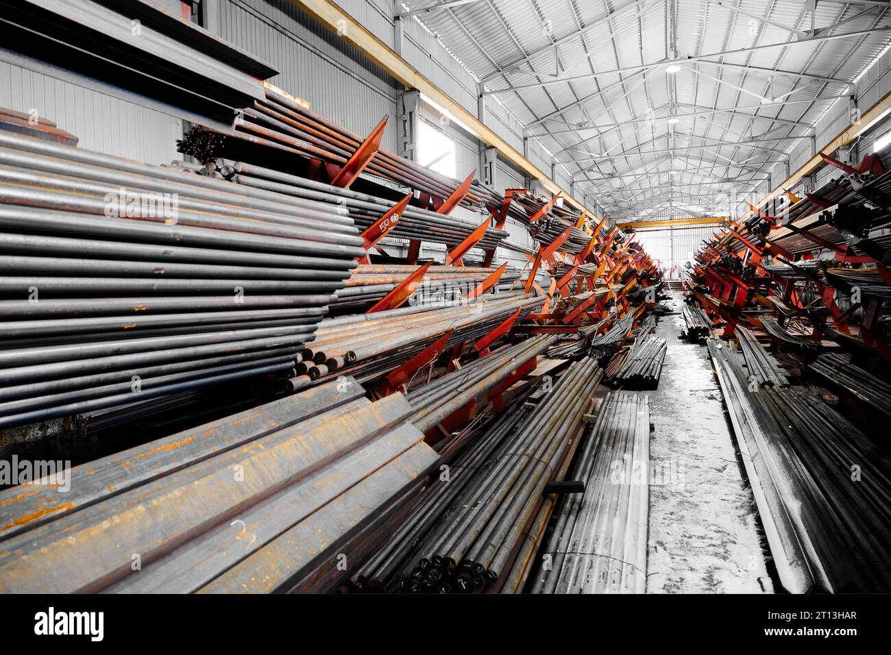 Dünne Metallstäbe stapeln sich auf einem großen Regal im Kühllager Stockfoto