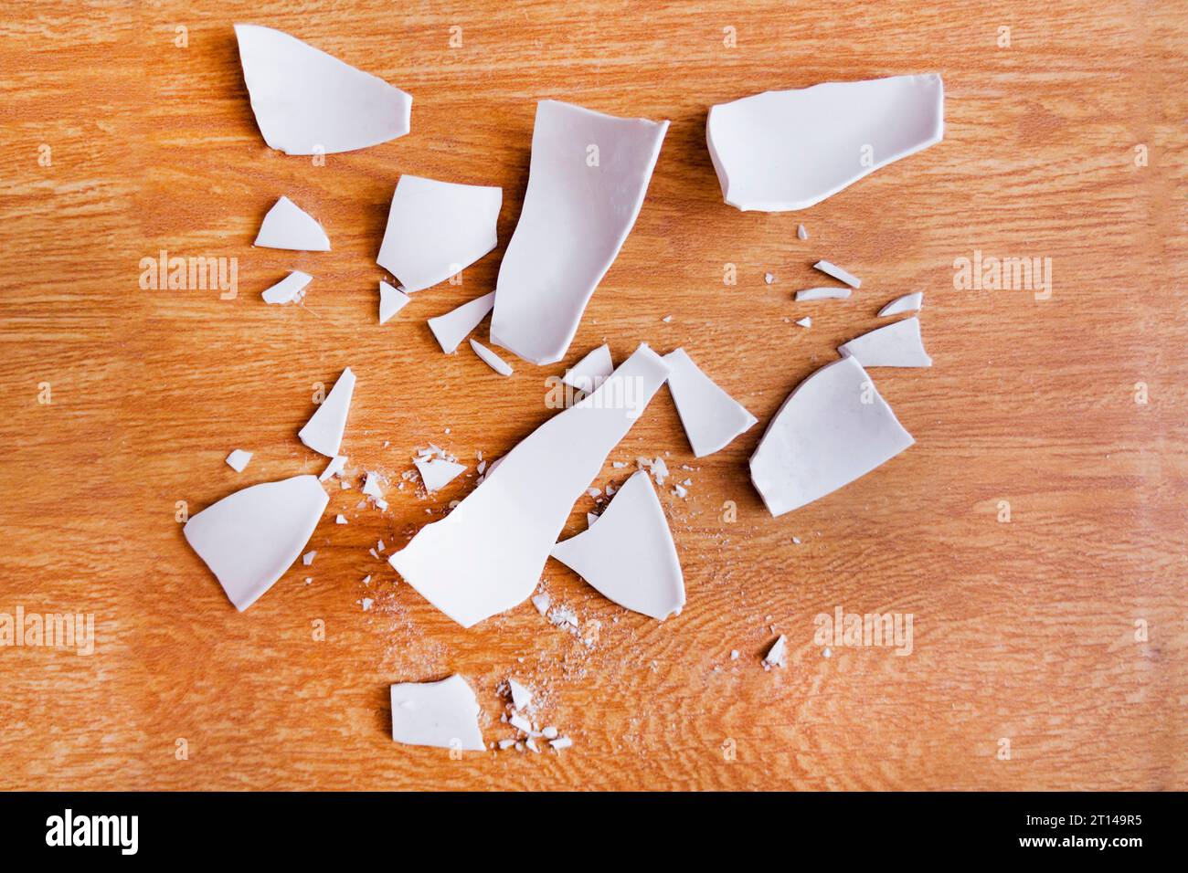 Scherben auf dem Hintergrund. Splitter, Fragmente eines Geschirrs auf dem Boden. Trümmer und Stücke eines gebrochenen Teller, Schale Stockfoto