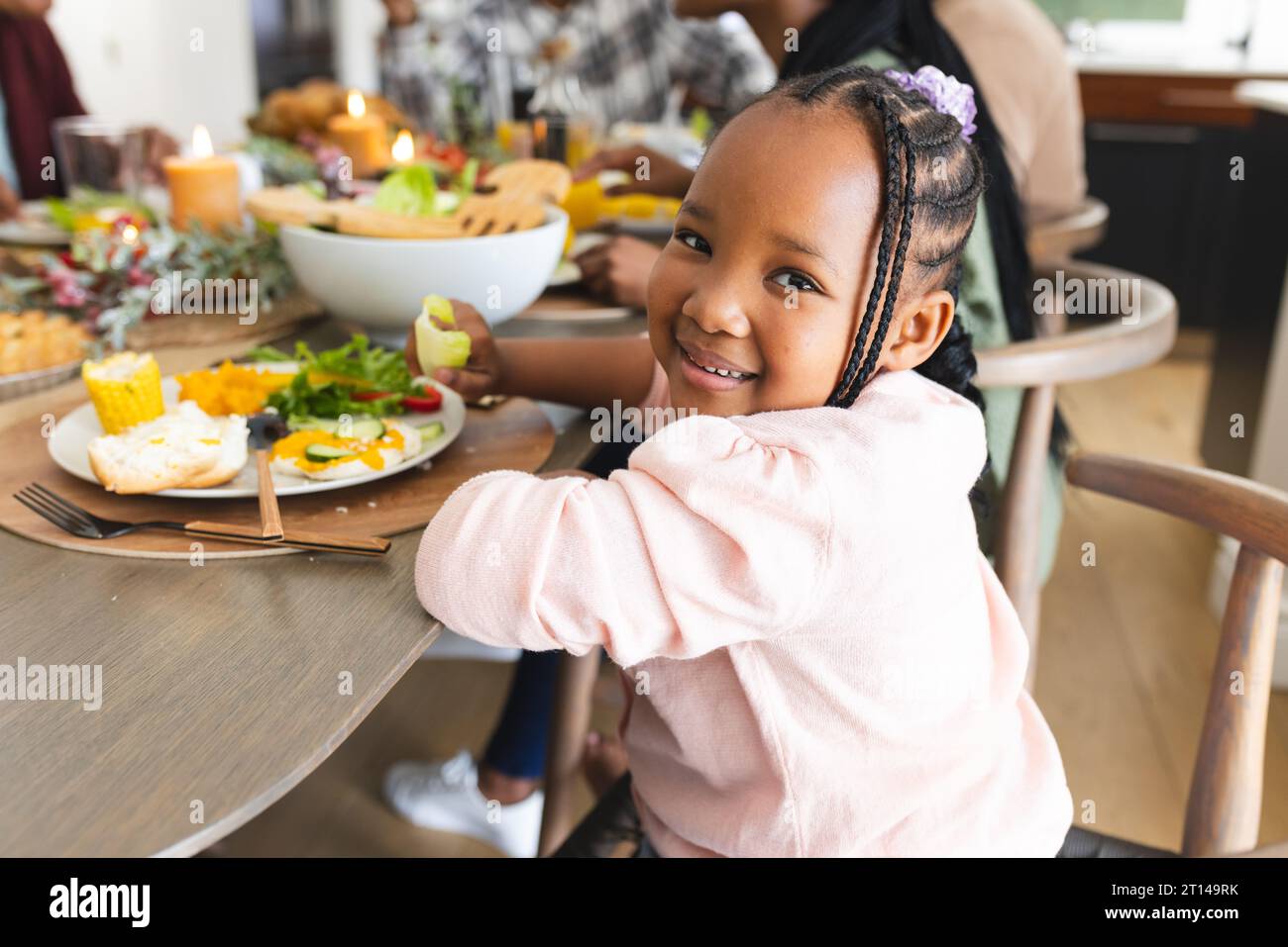 Porträt einer afroamerikanischen Tochter, die am Thanksgiving-Esstisch lächelt Stockfoto