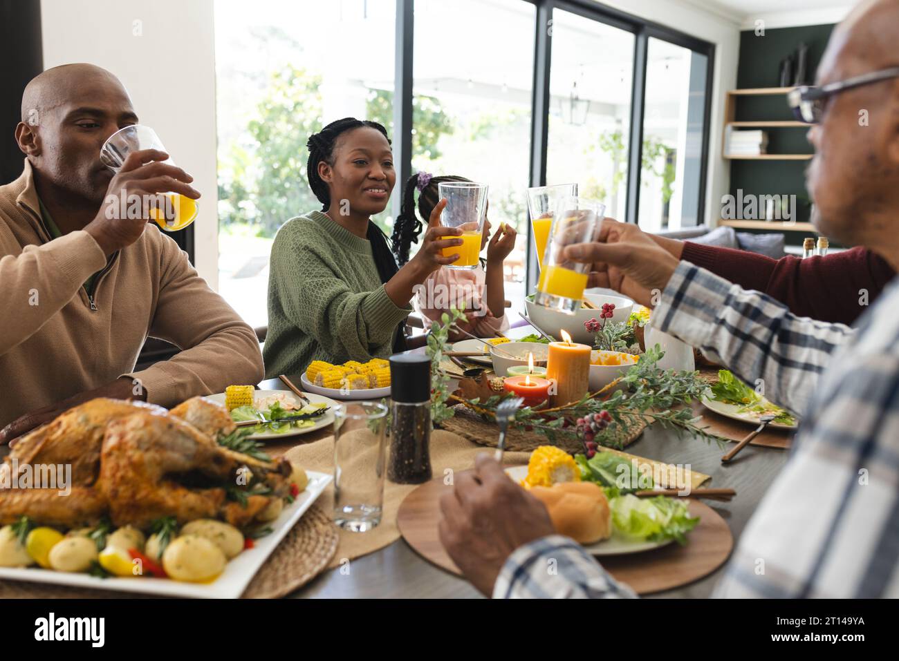 Glückliche afroamerikanische Familie, die mehrere Generationen beim Thanksgiving-Dinner einen Toast macht Stockfoto