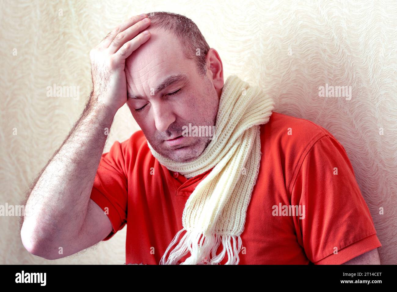 Ein kranker Mann hält seine Hand über seinen Kopf. Der Patient hat Kopfschmerzen. Kopfschmerzen. Konzept krank, ungesund. Sich krank und müde fühlen. Mann fühlt sich schlecht Stockfoto