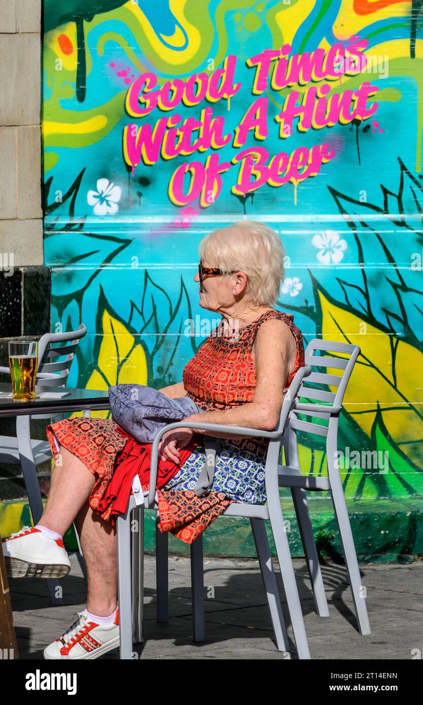 London, Großbritannien. Camden Town – ältere Frau mit einem Bier in der Camden High Street Stockfoto