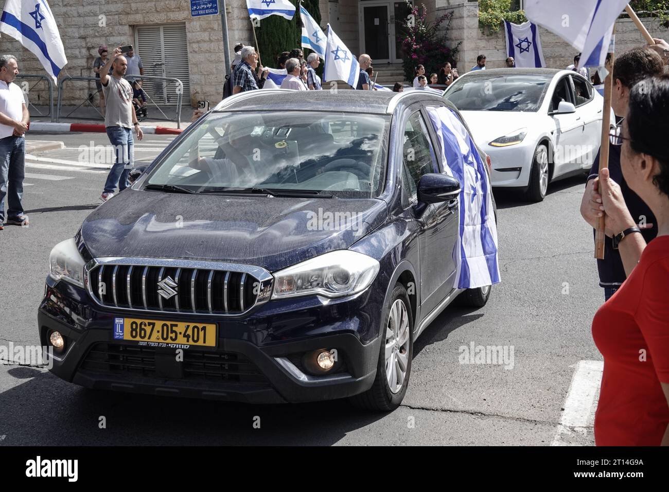 Jerusalem, Israel. Oktober 2023. Trauerprozession für IDF Golani Brigade Sgt Adi Tzur verlässt das Haus der Familie, während Hunderte mit israelischen Fahnen die Straße säumen, um ihren Respekt und Dankbarkeit für sein Opfer zu zollen. Tzur war unter Hunderten, die nach dem massiven Raketenfeuer aus dem Gazastreifen auf Israel am 7. Oktober 2023, der Infiltration von bewaffneten Männern auf israelisches Territorium, dem Massaker an Frauen und Kindern in ihren Häusern und der Geiselnahme von Zivilisten und Soldaten nicht mehr bekannt waren. Israel ist in einen Krieg mit der Hamas im Gazastreifen verwickelt. 300.000 Reservisten und die IS wurden eingesetzt Stockfoto