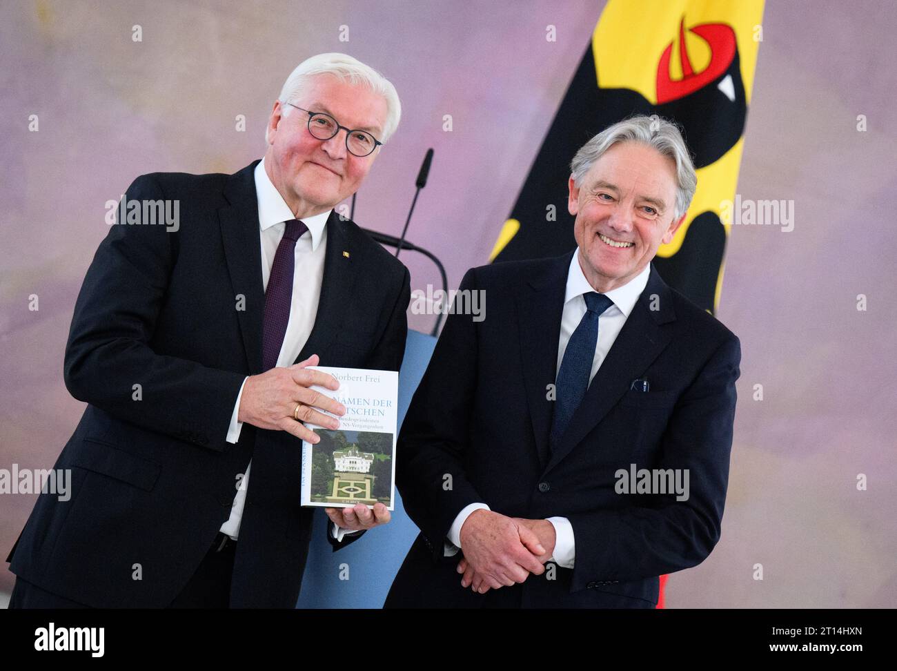 11. Oktober 2023, Berlin: Bundespräsident Frank-Walter Steinmeier (l) hält das Buch „im Namen der Deutschen“. Die Bundespräsidenten und die NS-Vergangenheit“ von Professor Norbert frei (r) in der Hand. Ein Forscherteam um den Historiker frei von der Friedrich-Schiller-Universität Jena hat die Biografien und Mandate der sechs deutschen Präsidenten von 1949 bis 1994 untersucht. Darüber hinaus Reden und Staatsbesuche der Bundespräsidenten, ihr Umgang mit NS-Tätern, die Gedenkfeier an Opfer von NS-Verbrechen sowie Ernennungen und die Verleihung von Befehlen des Bundes Stockfoto