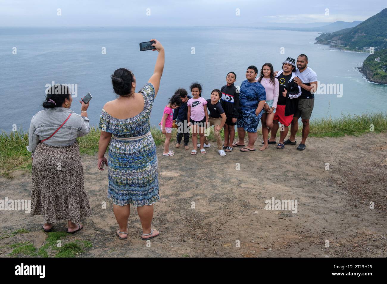 Eine Familie der Pazifikinseln steht für ein Gruppenfoto am bald Hill Lookout, Stanwell Tops, New South Wales, Australien Stockfoto