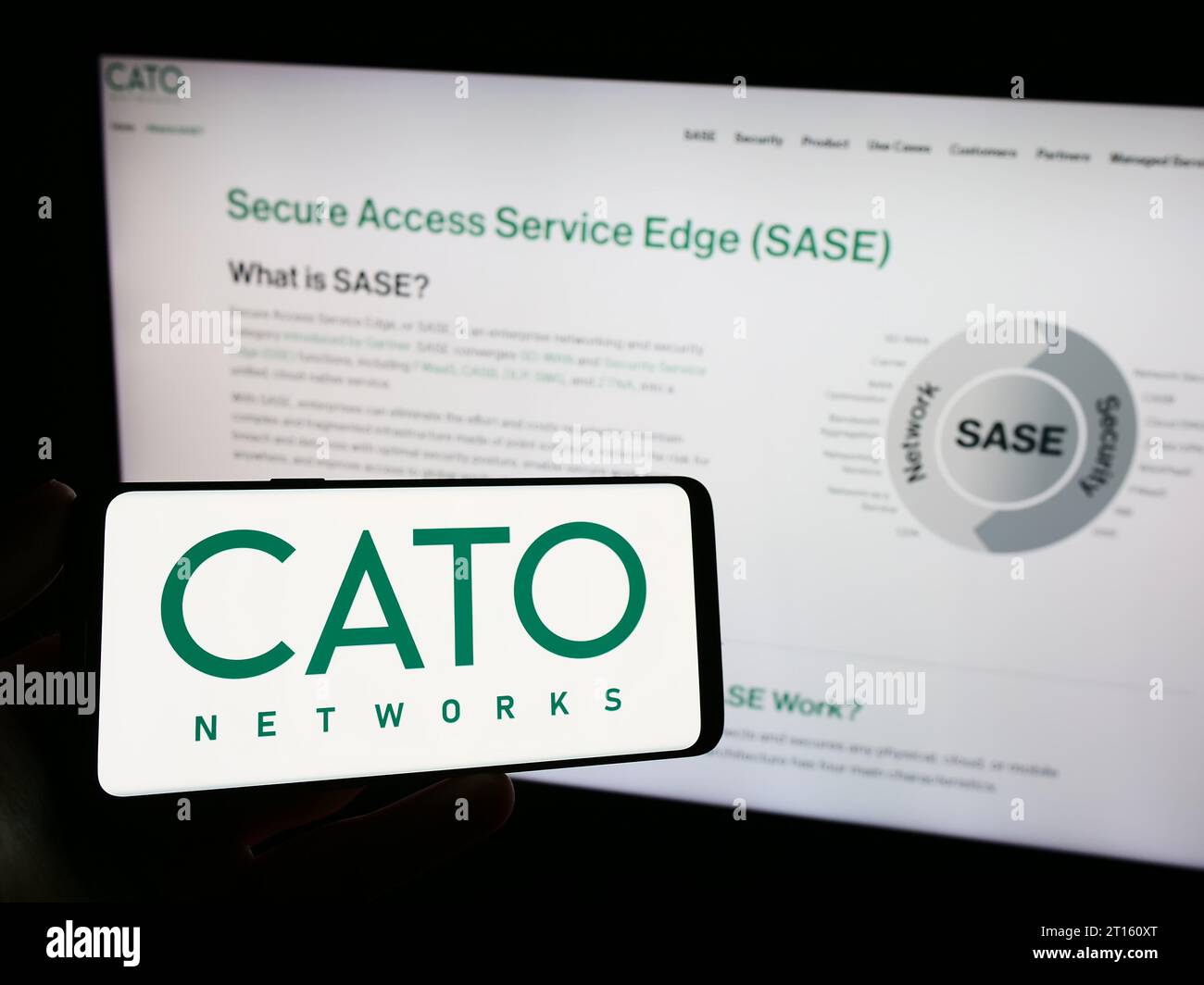 Person, die ein Mobiltelefon mit dem Logo des israelischen Netzsicherheitsunternehmens Cato Networks Ltd. Vor der Webseite hält. Schwerpunkt auf dem Display des Telefons. Stockfoto