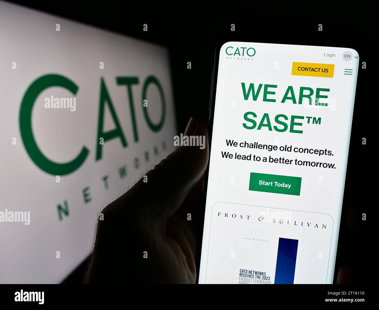Person, die ein Mobiltelefon hält, mit der Webseite des israelischen Netzwerksicherheitsunternehmens Cato Networks Ltd. Vor dem Logo. Konzentrieren Sie sich auf die Mitte des Telefondisplays. Stockfoto