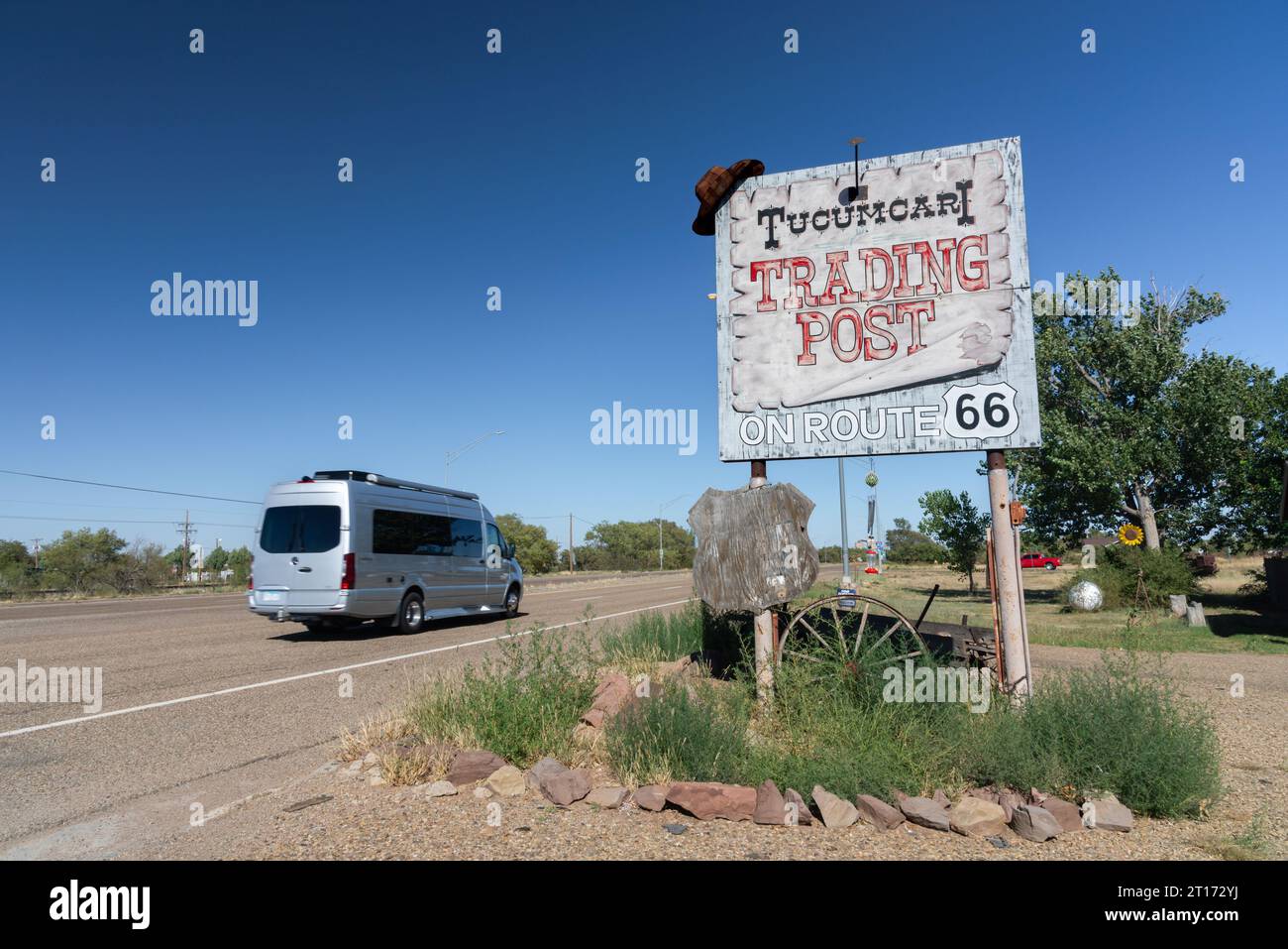 Ein Wohnmobil auf der historischen Route 66, der Mother Road, fährt an einem verwitterten hölzernen Schild für den Tucumcari Trading Post in Tucumcari, New Mexico, USA vorbei. Stockfoto