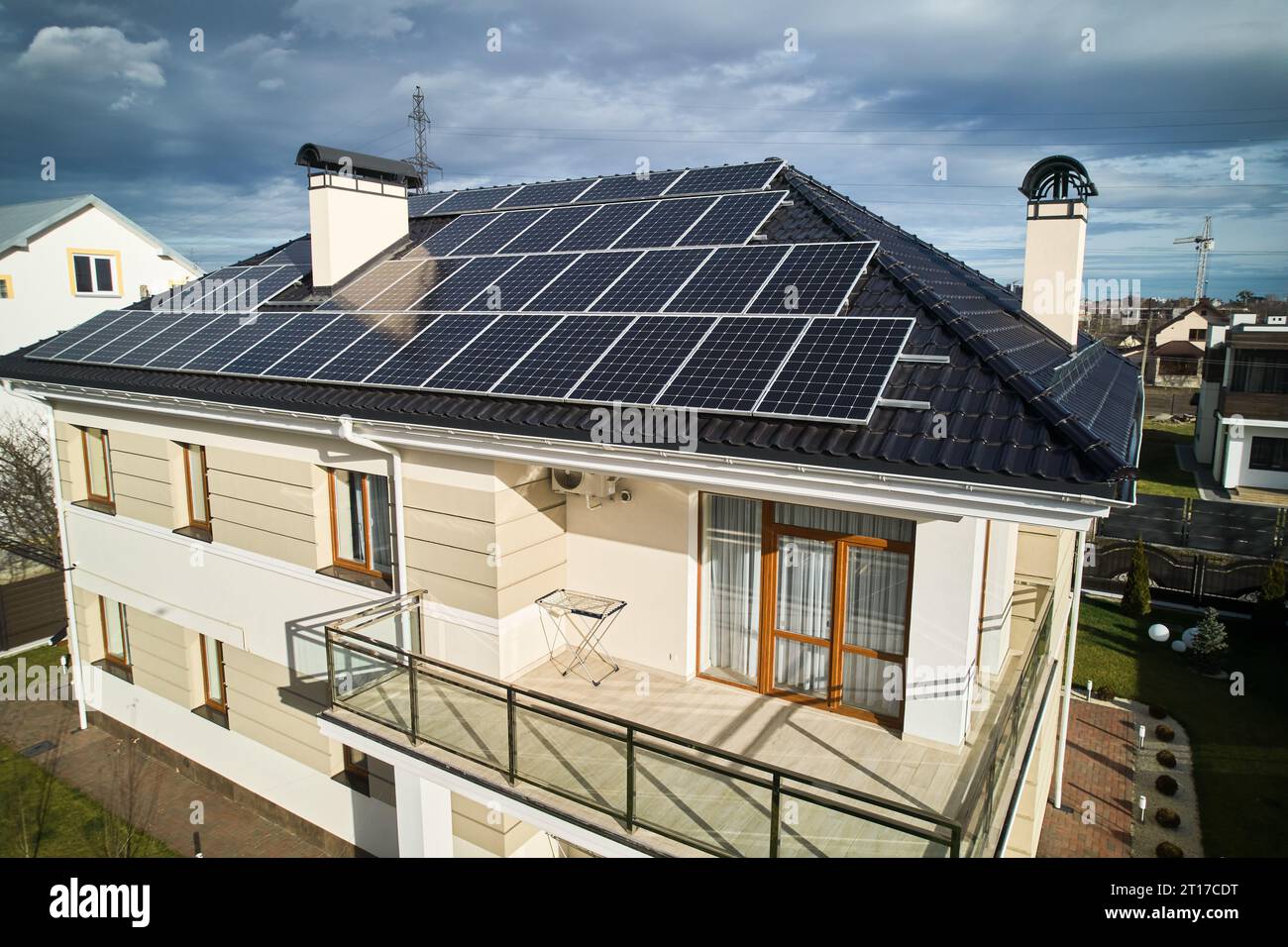 Wohnsitz mit Solarpaneelsystem zur Stromerzeugung durch Photovoltaik. Luftaufnahme des zweistöckigen Hauses mit Solarmodulen auf dem Dach. Konzept ökologischer erneuerbarer Energiequellen. Stockfoto